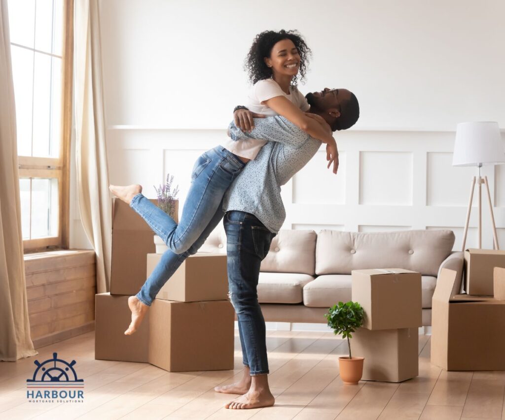 FIRST HOME PURCHASE A YOUNG BLACK COUPLE IN A ROOM FILLED WITH BOXES AND A CREAM SOFA