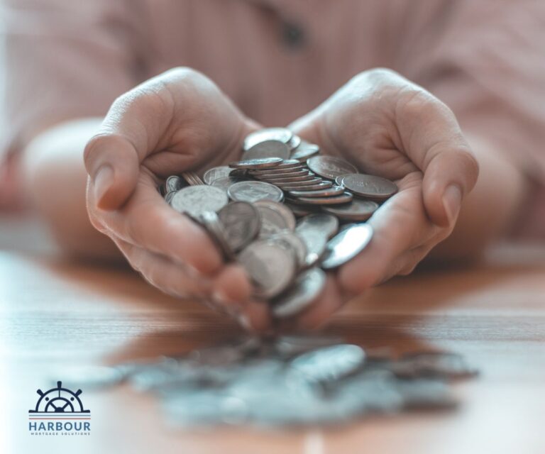 Income protection insurance hands in a heart shape holding a pile of coins that are cascading onto the desk