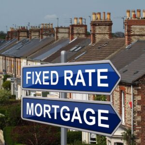 Signpost pointing towards a fixed-rate mortgage with a street of houses behind it