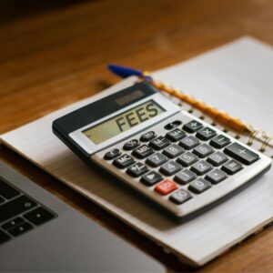 a calculator on a desk with the word FEES on its screen for the mortgage broker or bank blog